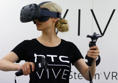 A woman checks a pair of Vive Virtual Reality goggles, produced by Taiwan's HTC, during the Gamescom 2015 fair in Cologne
